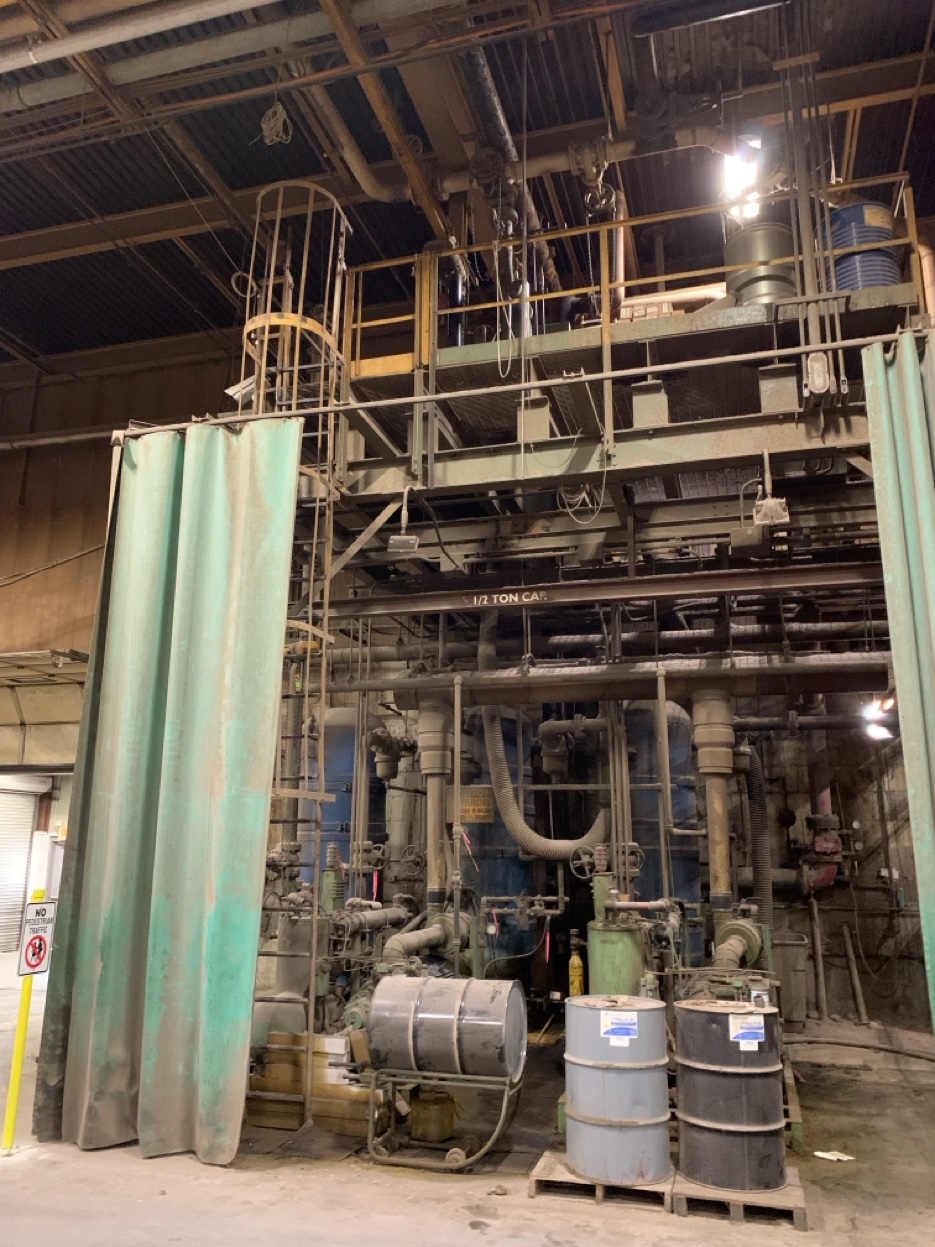 Detail of old compressor with oxidized curtains, manual valves, and aging infrastructure